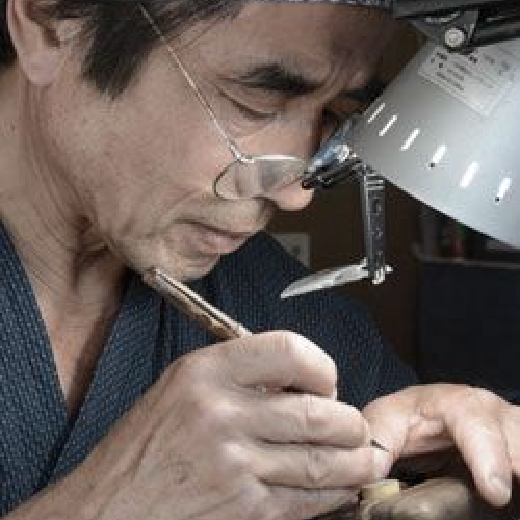 印鑑を掘る眼鏡をかけた男性
